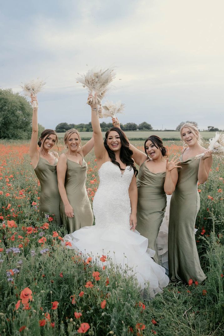 Bridesmaids in sage green cowl neck satin bridesmaid dresses with bride in mermaid wedding dress 