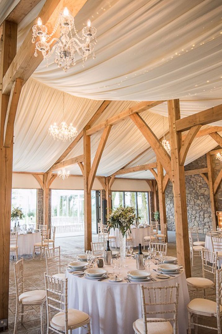 Rustic barn wedding venue, Beaconside in Devonshire with white drapery and fairy light decorations 