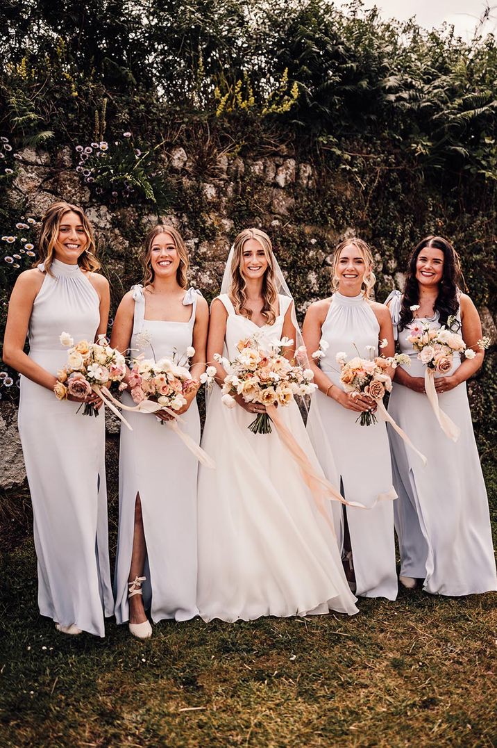 Bridal party wearing pastel powder blue bridesmaid dresses with neutral and pink tone wedding bouquets at The Wedding Present Company wedding