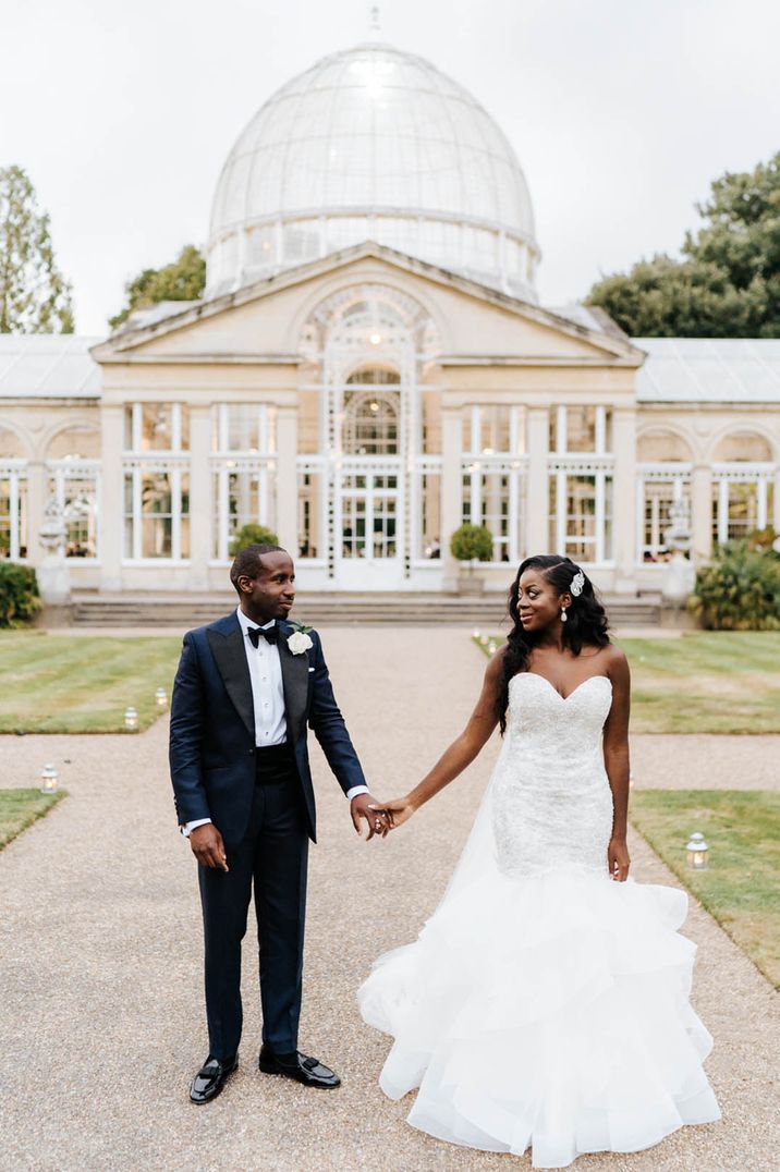 Bride in long strapless wedding dress and groom in black suit and tie at Catholic traditional wedding ceremony