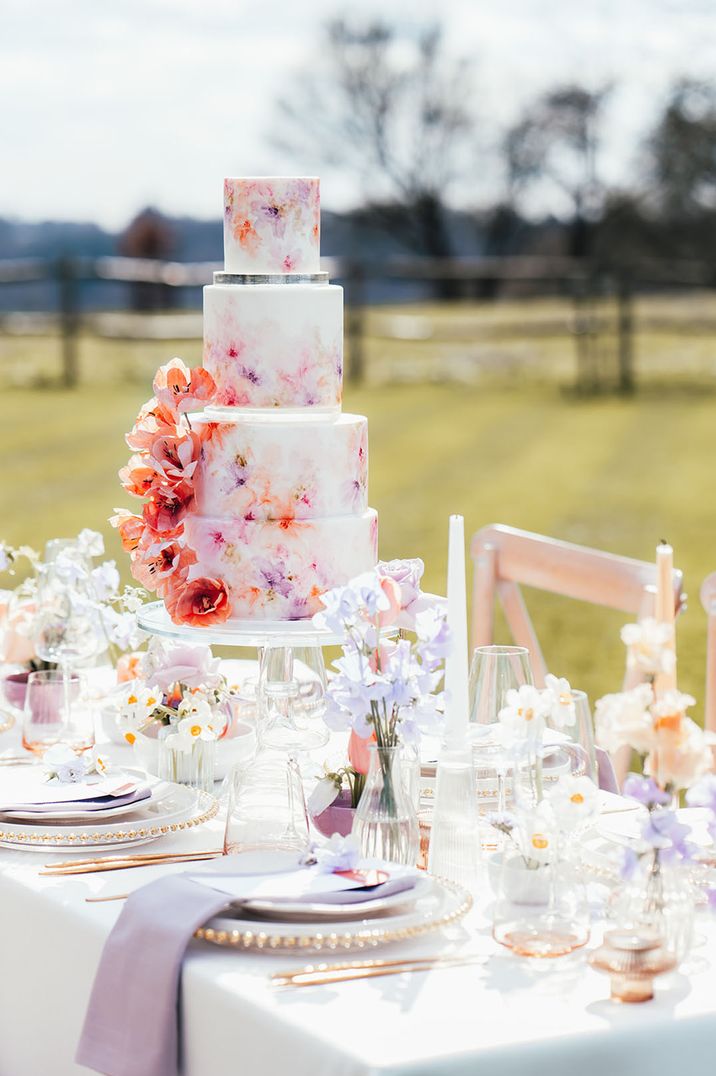 Incredible four tier white iced wedding cake with hand-painted water colour floral design with wafer flowers 