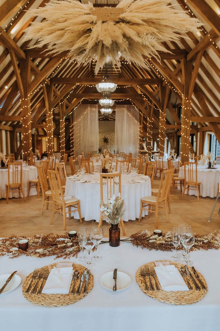 Autumnal rustic barn wedding venue with pampas grass, fairy lights, and other dried flowers 