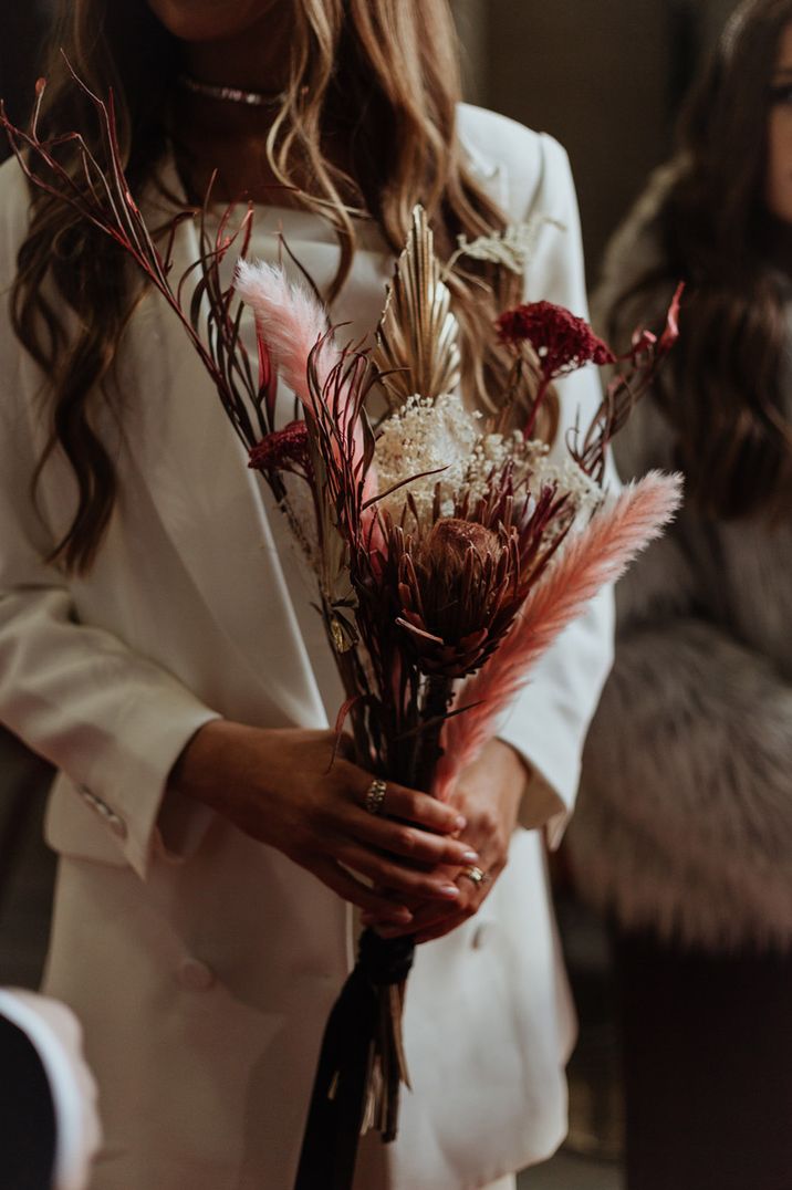 Dried palm leaves, dyed pink pampas grass and more in preserved flower wedding bouquet 