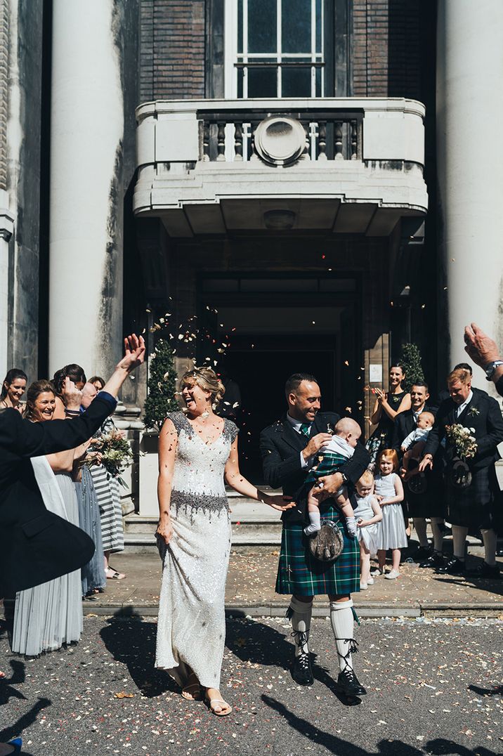 Confetti exit for bride and groom on their wedding day with the bride wearing a dropped waist vintage wedding dress 