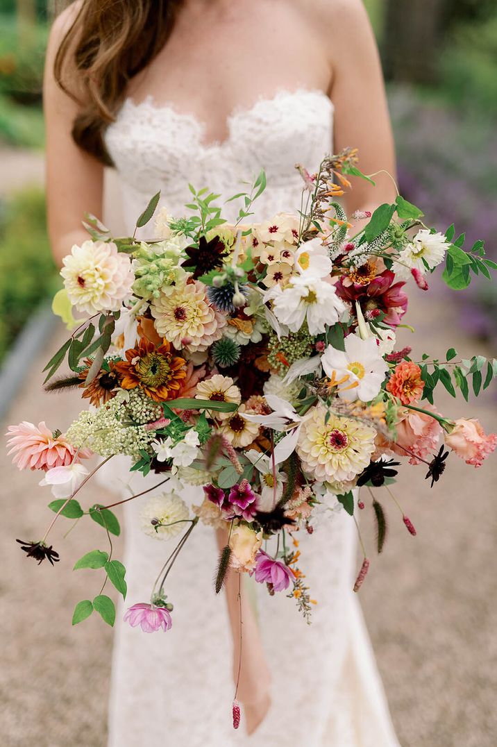 Bride holding colourful wildflower wedding bouquet