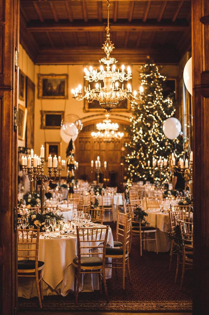 Cosy wedding venue lit with warm lighting with a Christmas tree in the corner of the room