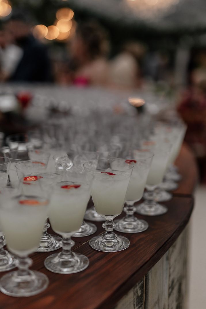 London bar with small glasses filled with spicy margarita cocktails topped with red chilli pepper 