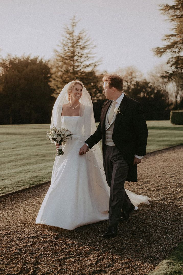 Couple at traditional wedding in long sleeve wedding dress and suit