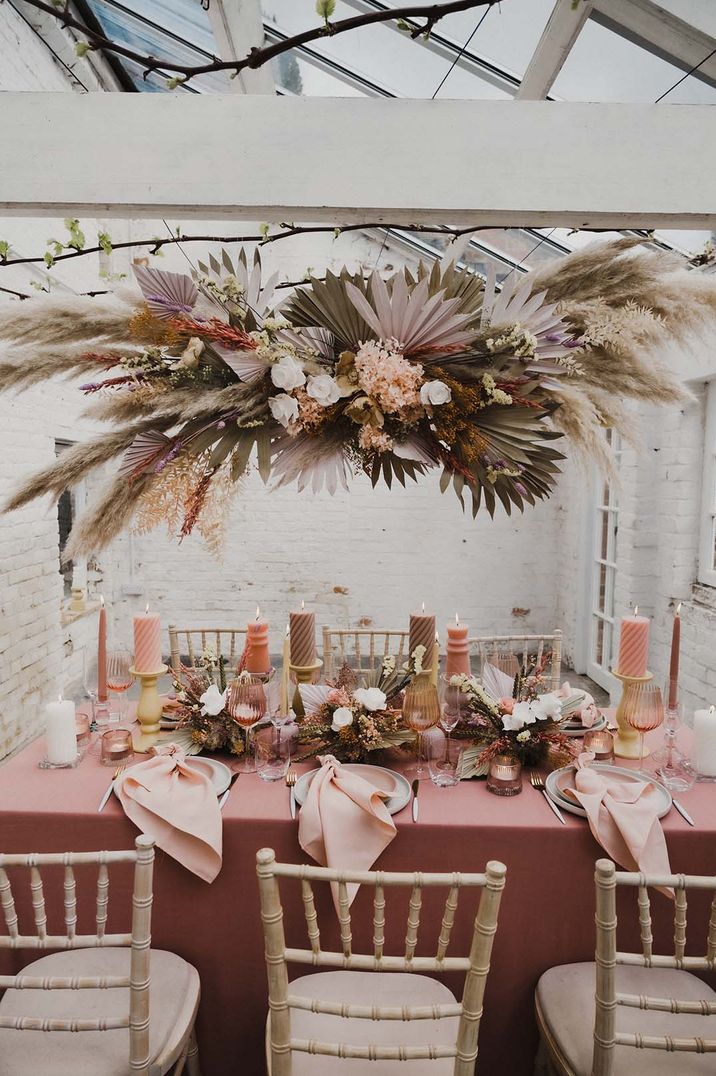 Horseshoe Flowers has created a pastel fresh and dried flower landscape for the table setting 