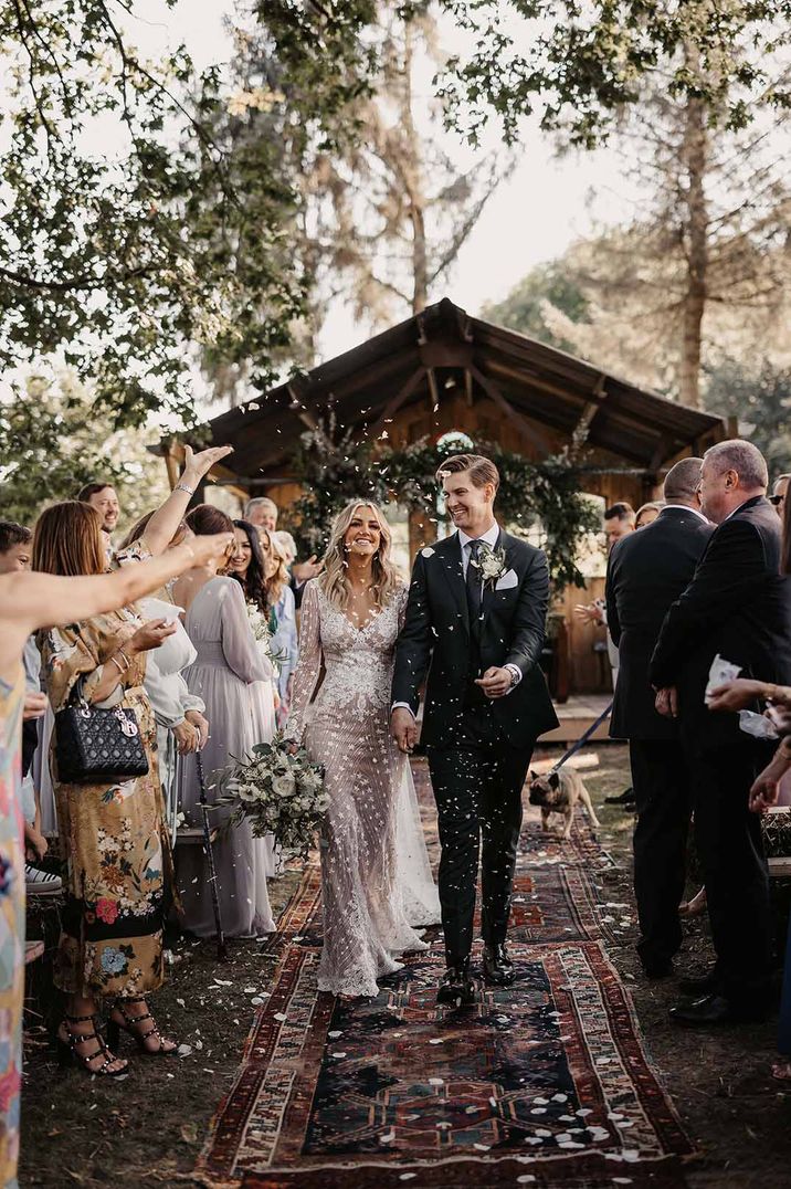 Outdoor ceremony with bride in a fitted lace wedding dress at Oak Tree Barn 