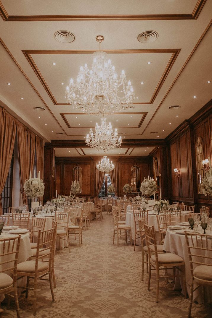 Hedsor House winter wedding venue with grand chandeliers and luxe tall white centrepieces 