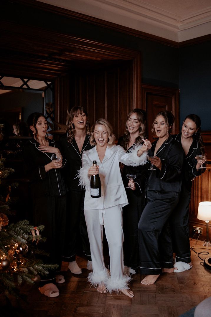 Bridal party with the bridesmaids in black satin long sleeve top and trousers pyjamas sets with the bride in a white version 