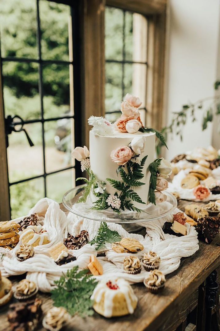 Pastel wedding dessert table with wildflower pressed wedding cake for spring wedding 