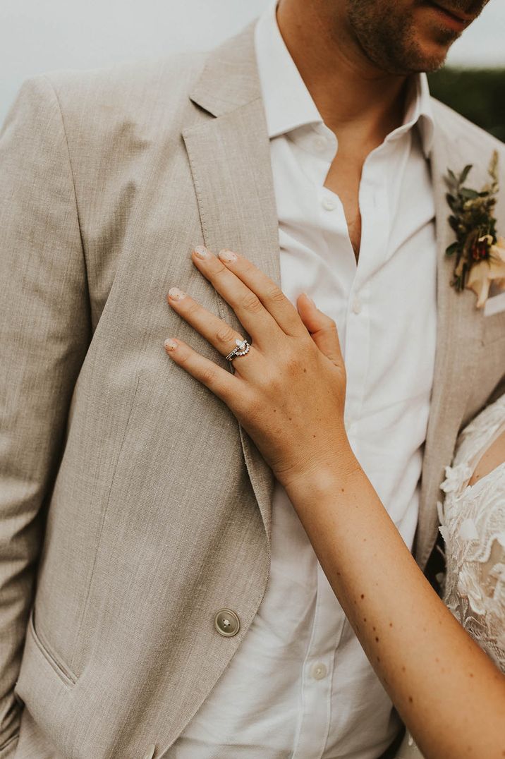 Bride with a unique engagement ring and wedding band with her hand on her grooms chest