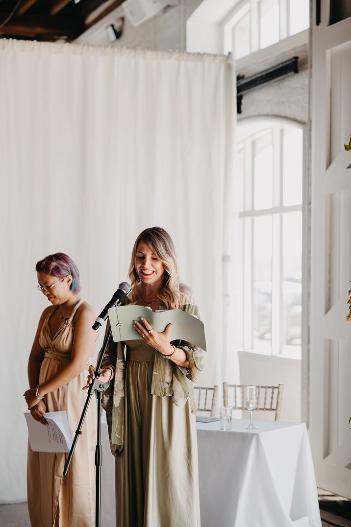 Celebrant in sage green dress conducting the wedding ceremony 