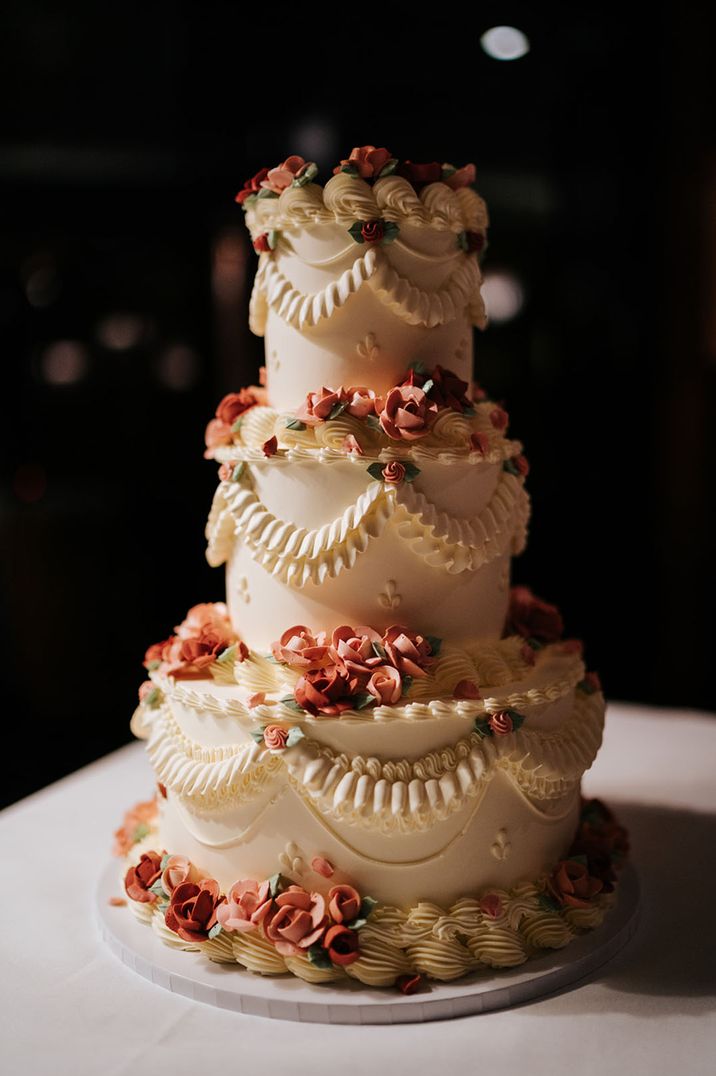 Vintage wedding cake with delicate iced roses for decoration at classic wedding 