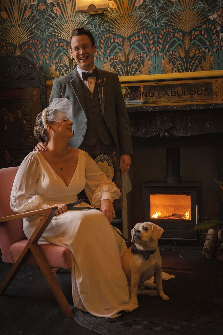 The happy couple on their wedding day with their pet dogs at their dog friendly wedding venue 