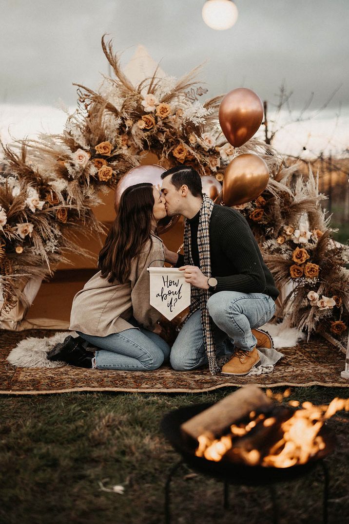 Wedding proposal between bride and groom in boho bell tent with dried wedding flower decorations 