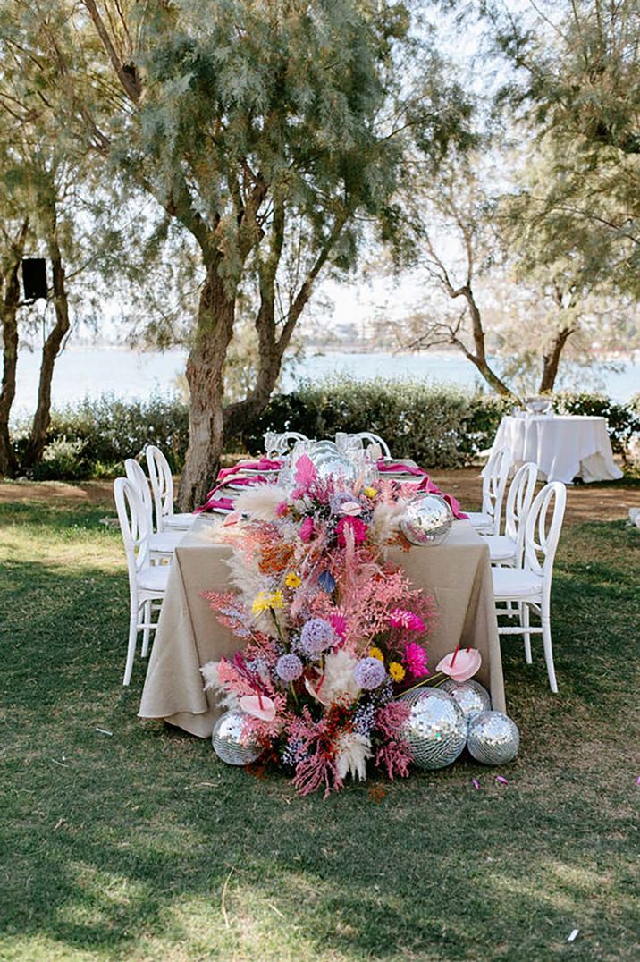 Table set up including pink flowers and disco balls for greek wedding by Anestis Papakonstantinou Photography 