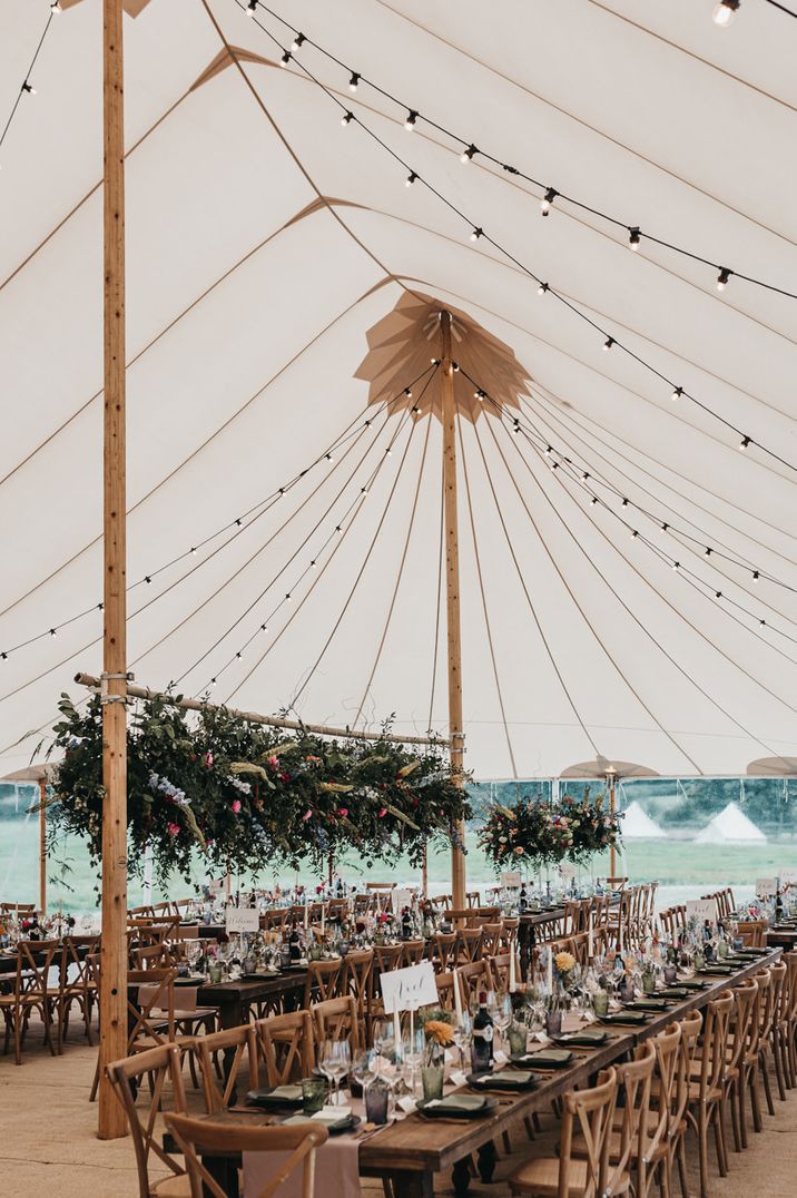 Sperry Tent wedding reception with festoon lights decor and colour flower installation over the reception tables