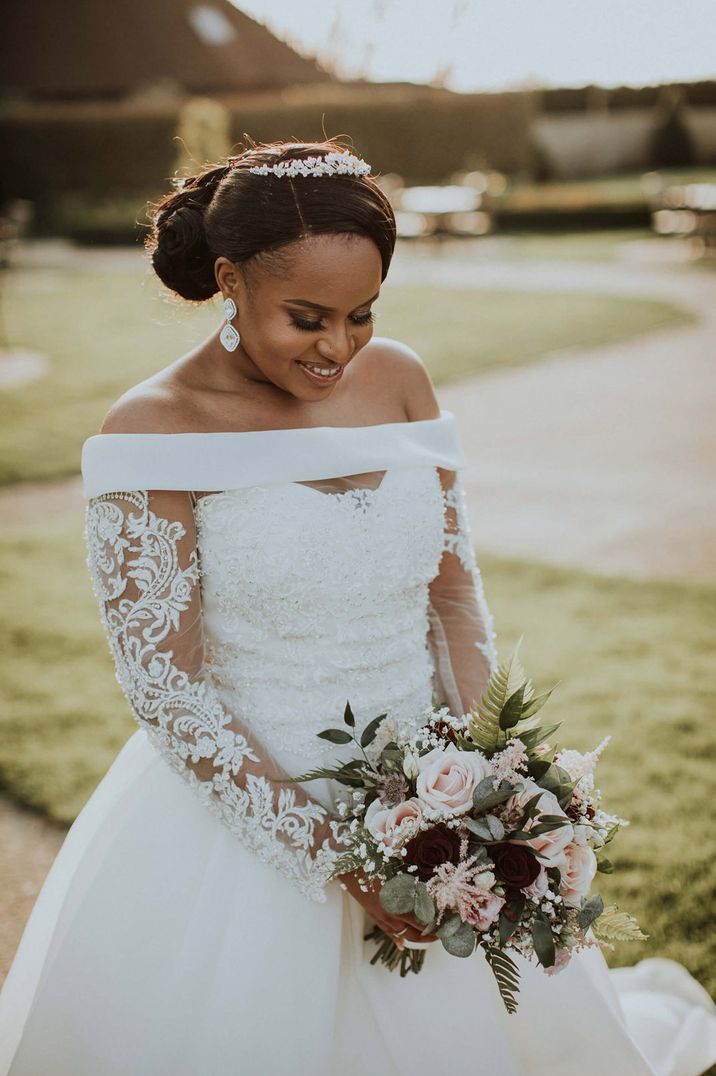 Black bride in an off the shoulder wedding dress with lace long sleeves 