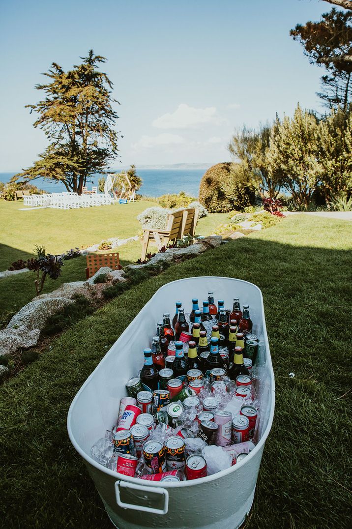 White metal bath tub filled with booze and alcohol as fun and relaxed wedding bar design idea 