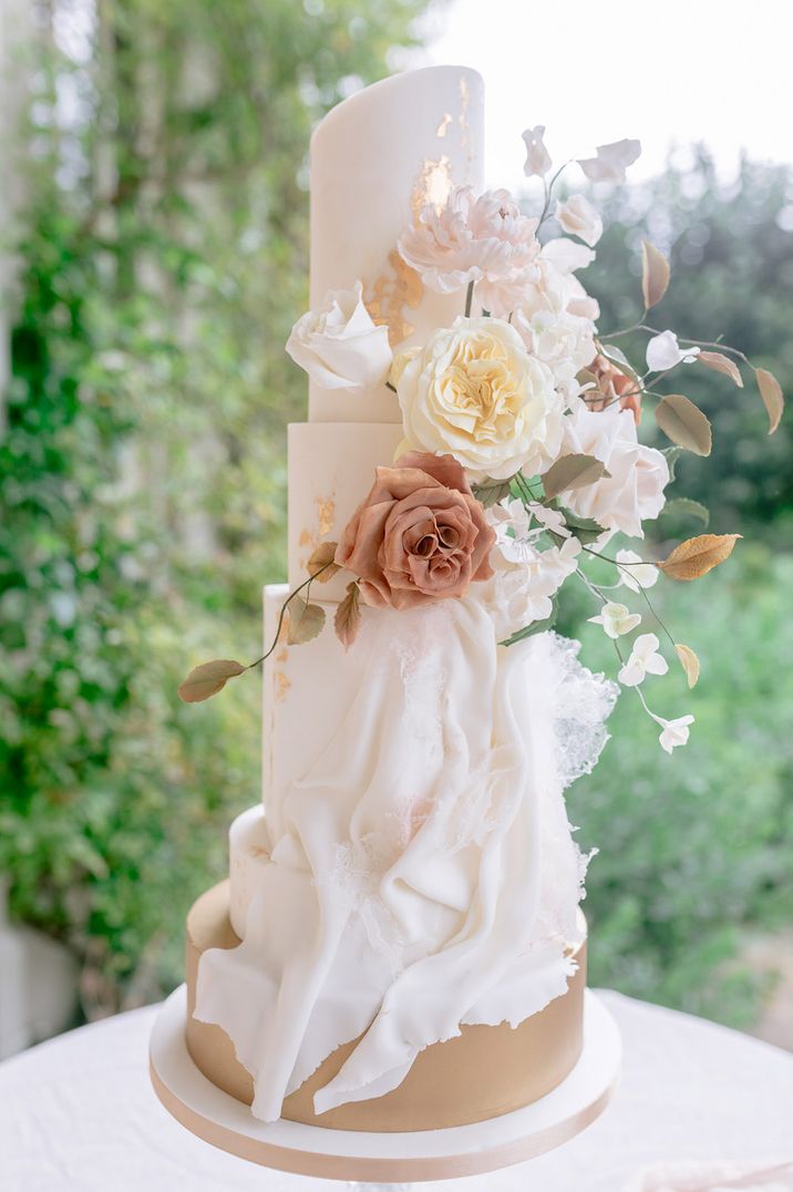 Wedding cake decorated with white and cream wedding flower decorations 