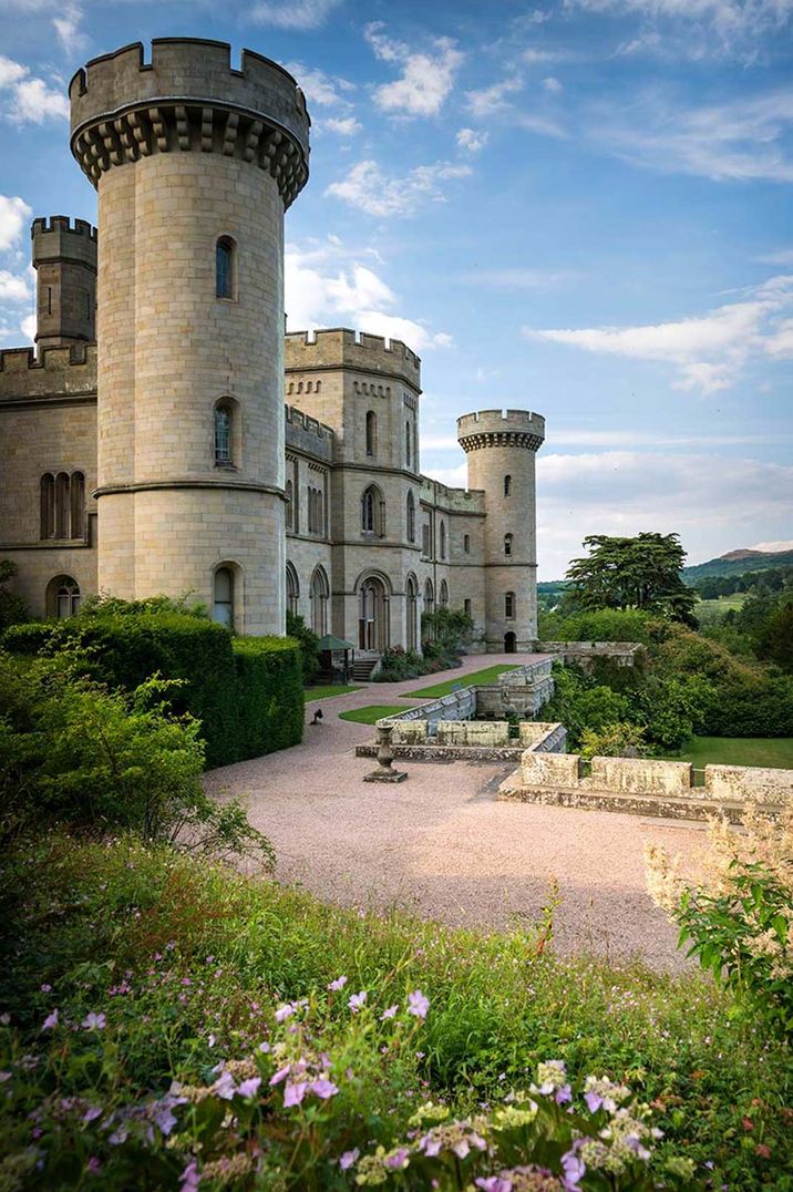 Exterior of Eastnor Castle wedding venue on a sunny day with manicured lawns and grounds