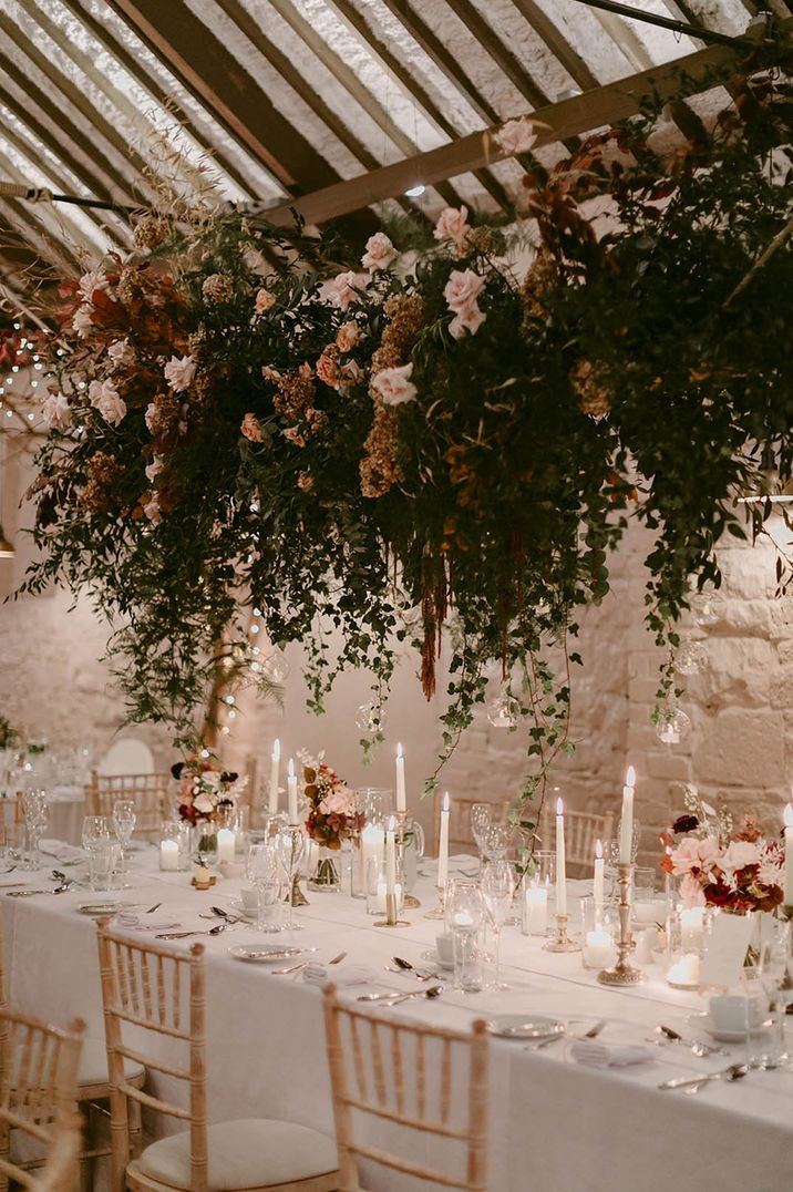 Pink rose wedding flower hanging installation over wedding table with white tablecloth 