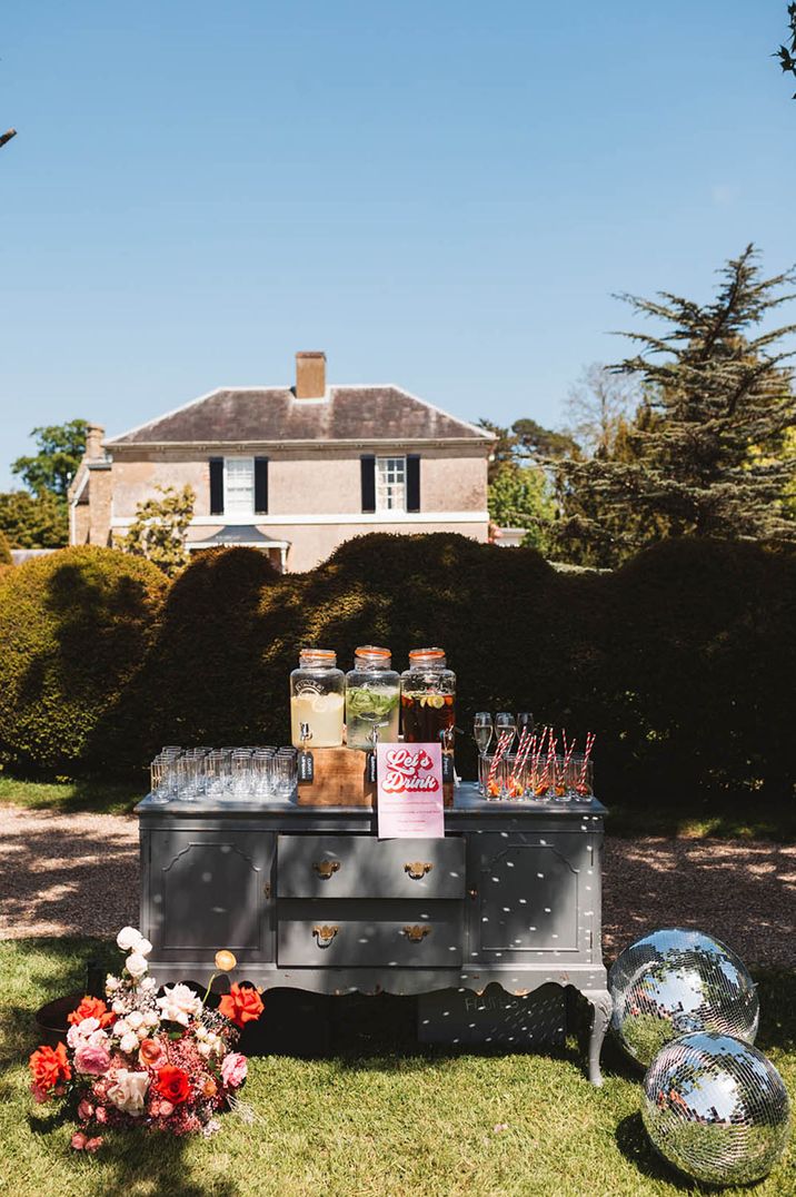 Outdoor hydration station for guests with large glass dispensers full of juice for wedding guests 