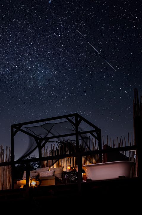 Image of honeymoon destination idea with star gazing bed at night and a sky full of stars, cosy and romantic