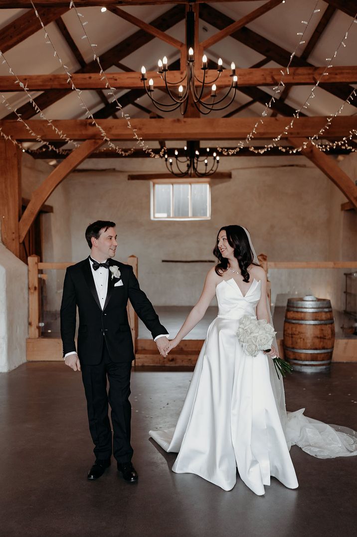 Bride in strapless wedding dress with white rose wedding bouquet with the groom at their Upton Barn wedding 