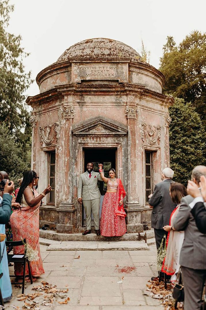 Bride and groom at multicultural wedding at Larmer Tree Gardens celebrate their wedding protected by wedding insurance 