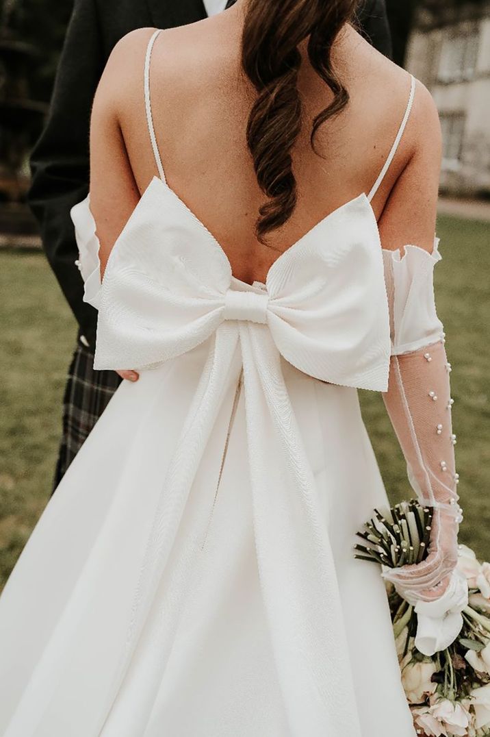 Bride wearing an oversized bow wedding dress with large decorative bow on the back by Sophie Alexandria Photography