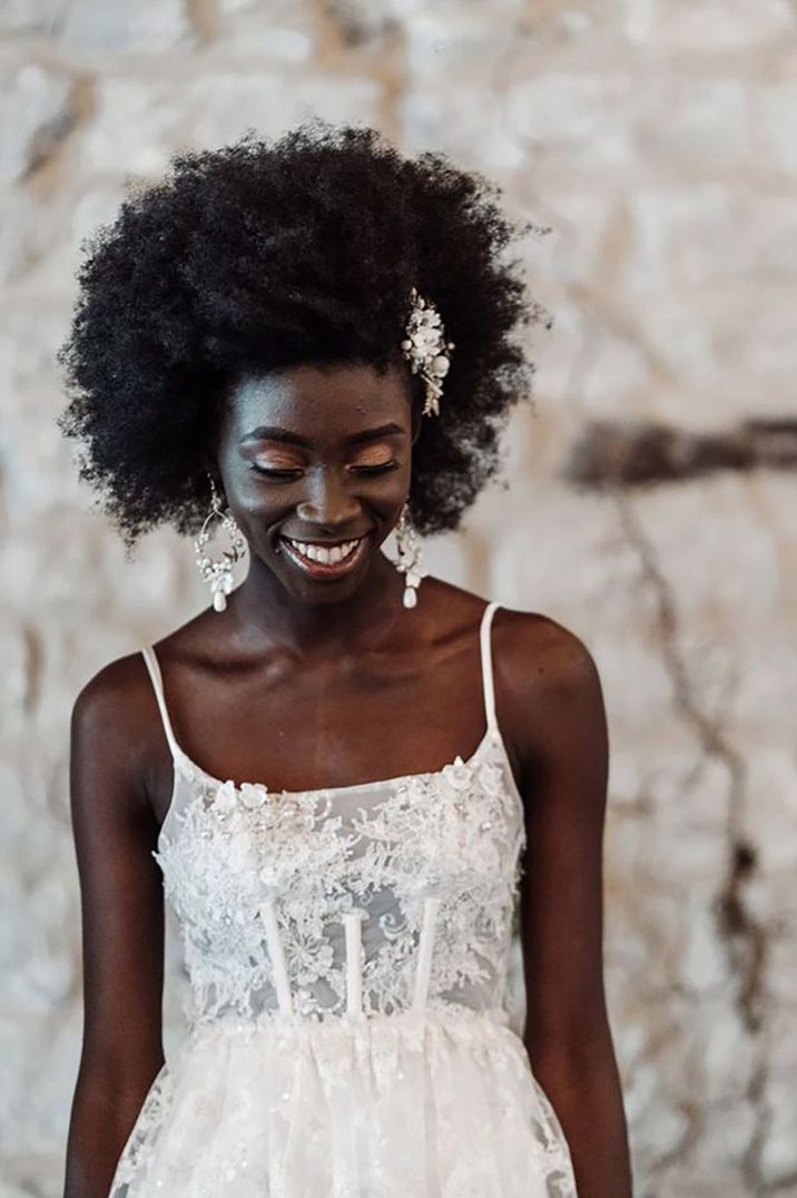 Bride with afro hair accessorises with pearl and diamond flower wedding hair accessory 