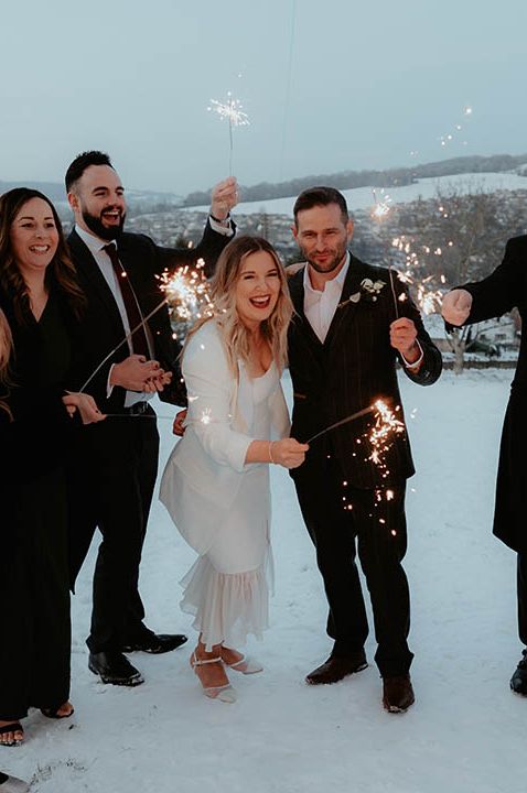 Bride in white midi wedding dress wearing white blazer for intimate micro wedding 