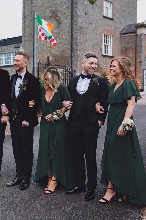 Groom party looking dapper in black suits and dark green groomsman dresses 