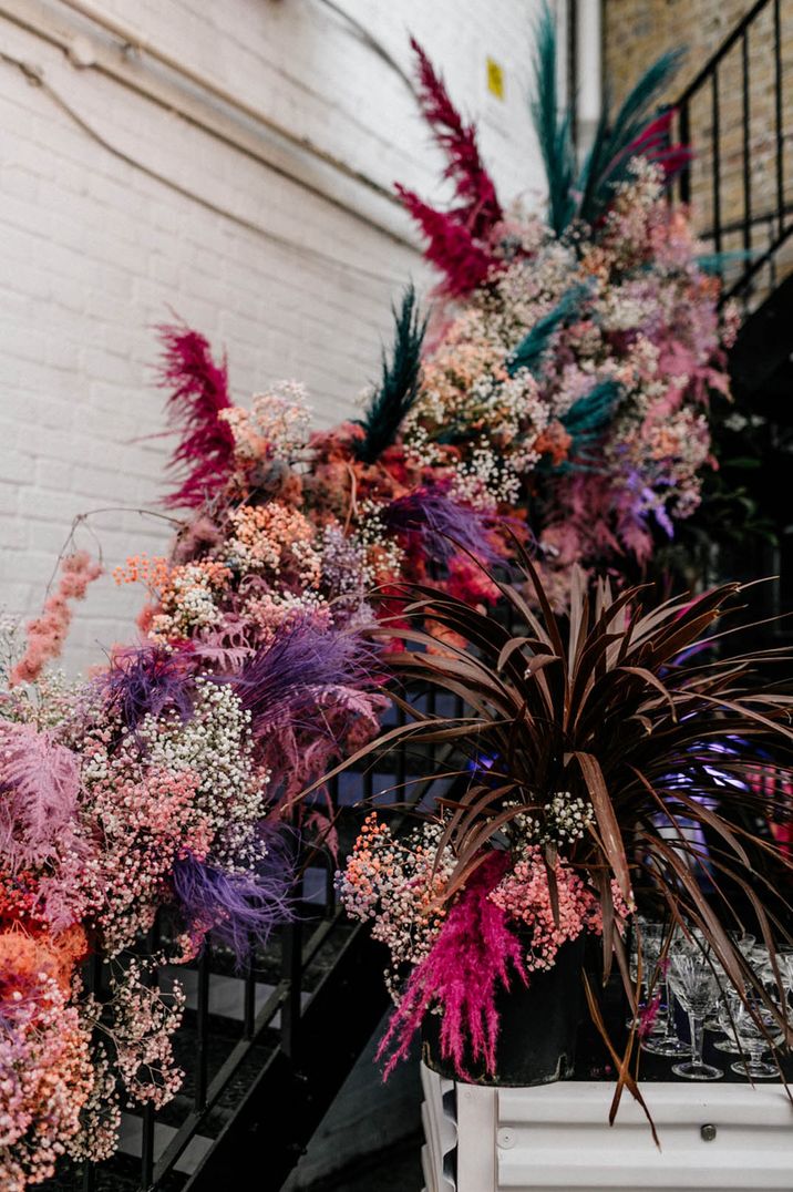 Bright pink, purple, red, and blue dyed pampas grass and gypsophila wedding flower stair decoration 