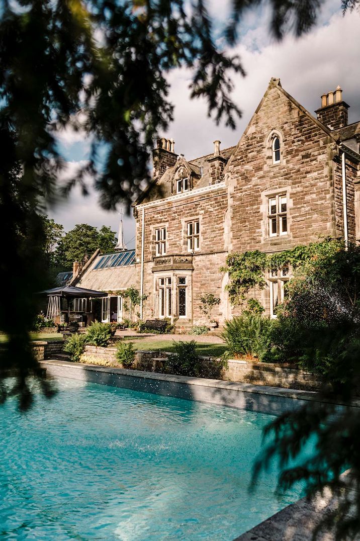 Exterior of Dunwood Hall Estate castle wedding venue with large 1920s art deco swimming pool 