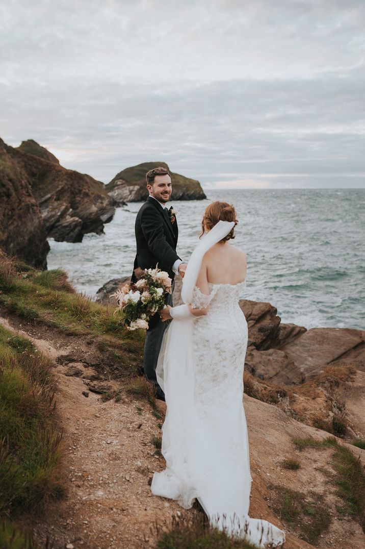 The bride and groom walking around the Devonshire wedding venue, Watermouth Cove