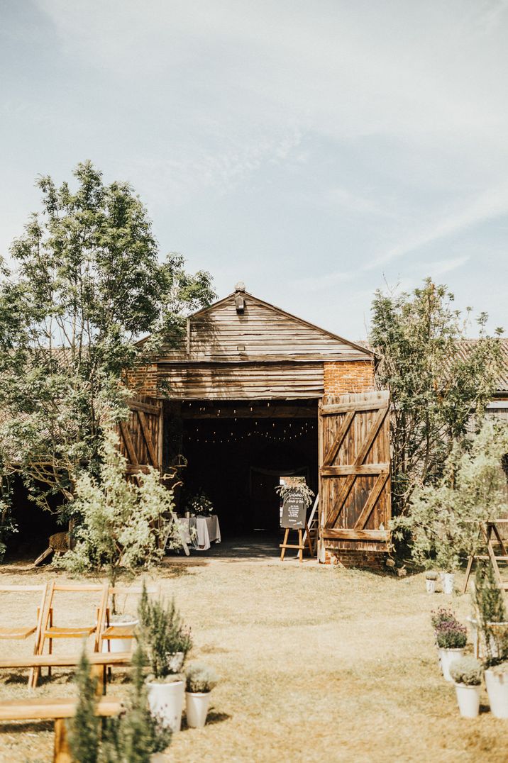 Outdoor boho wedding ceremony and barn reception with natural wedding decor and flowers