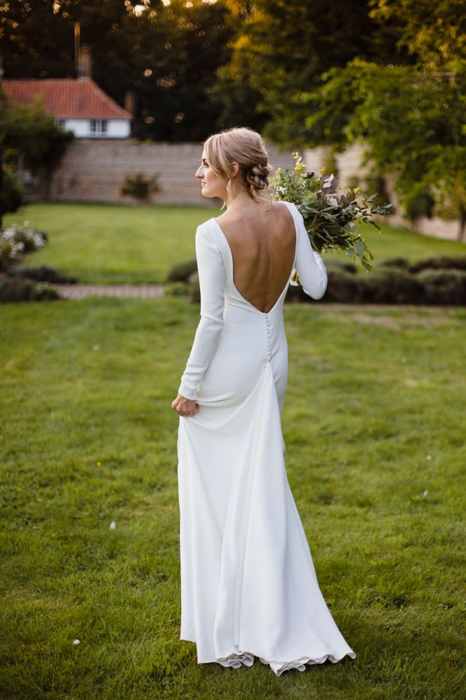 Bride in a fitted Pronovias wedding dress with long sleeves