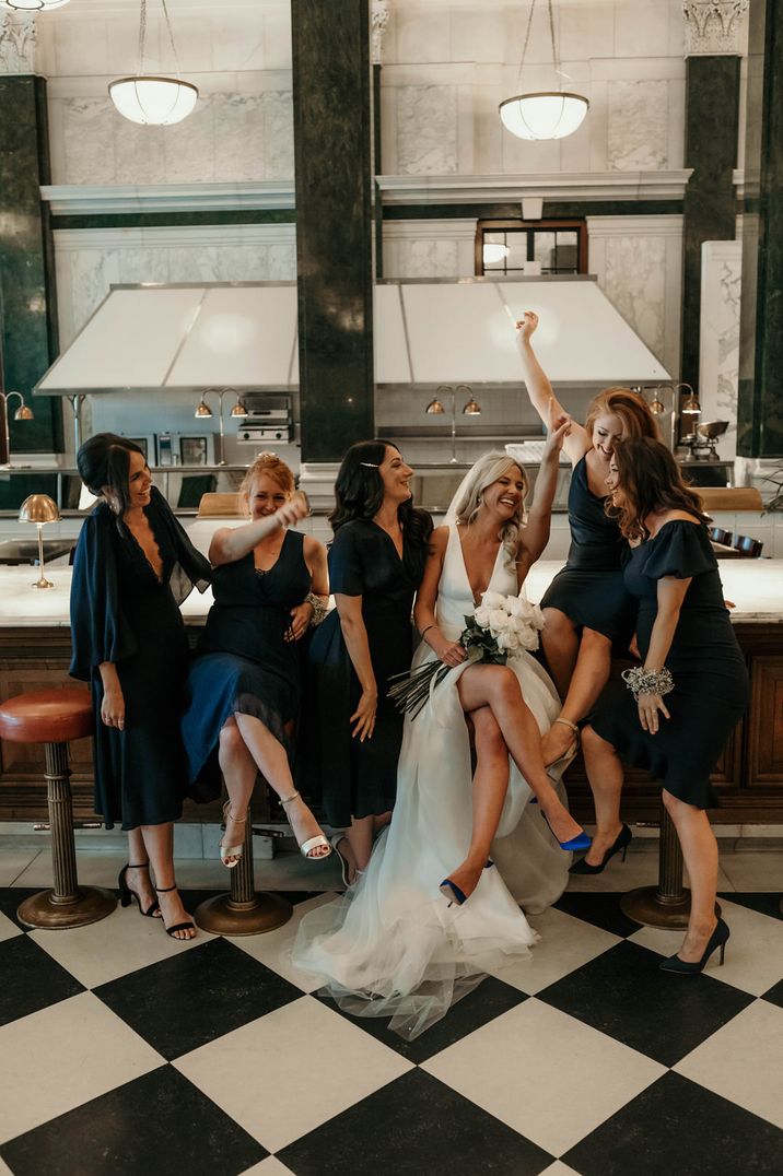 Bridal party portrait with bride in a princess wedding dress with her bridesmaids in navy dresses