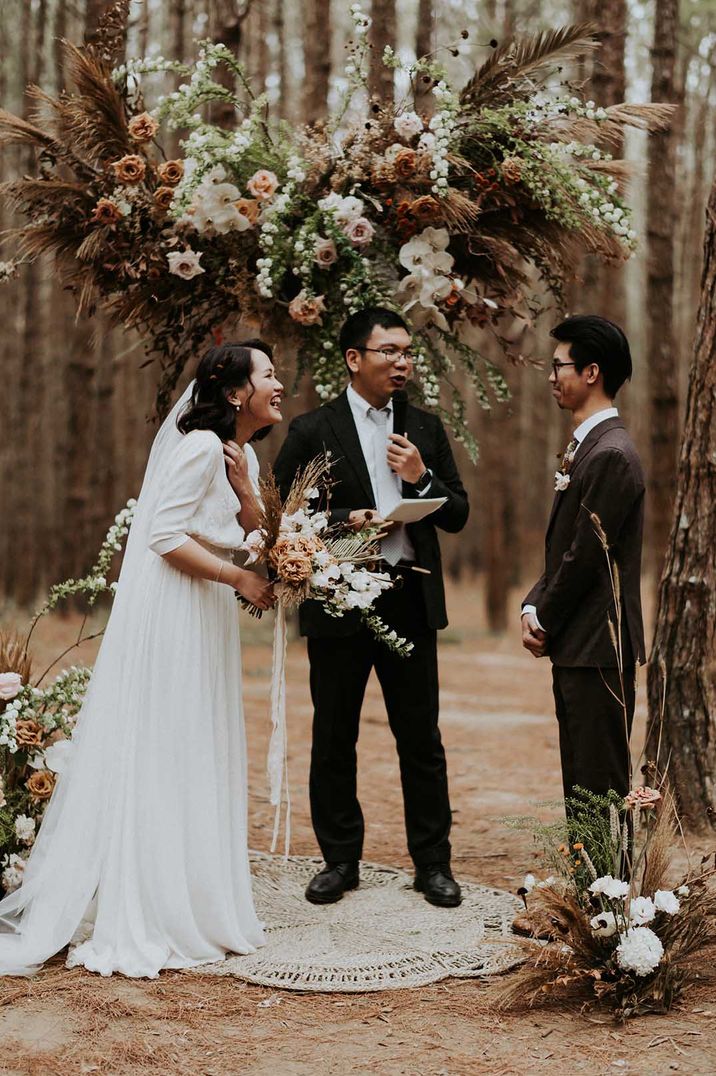 Woodland civil wedding ceremony with a wooden altar and flower installation  