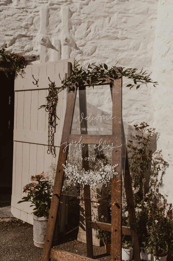 Glass wedding sign on wooden easel with boho fauna decorations