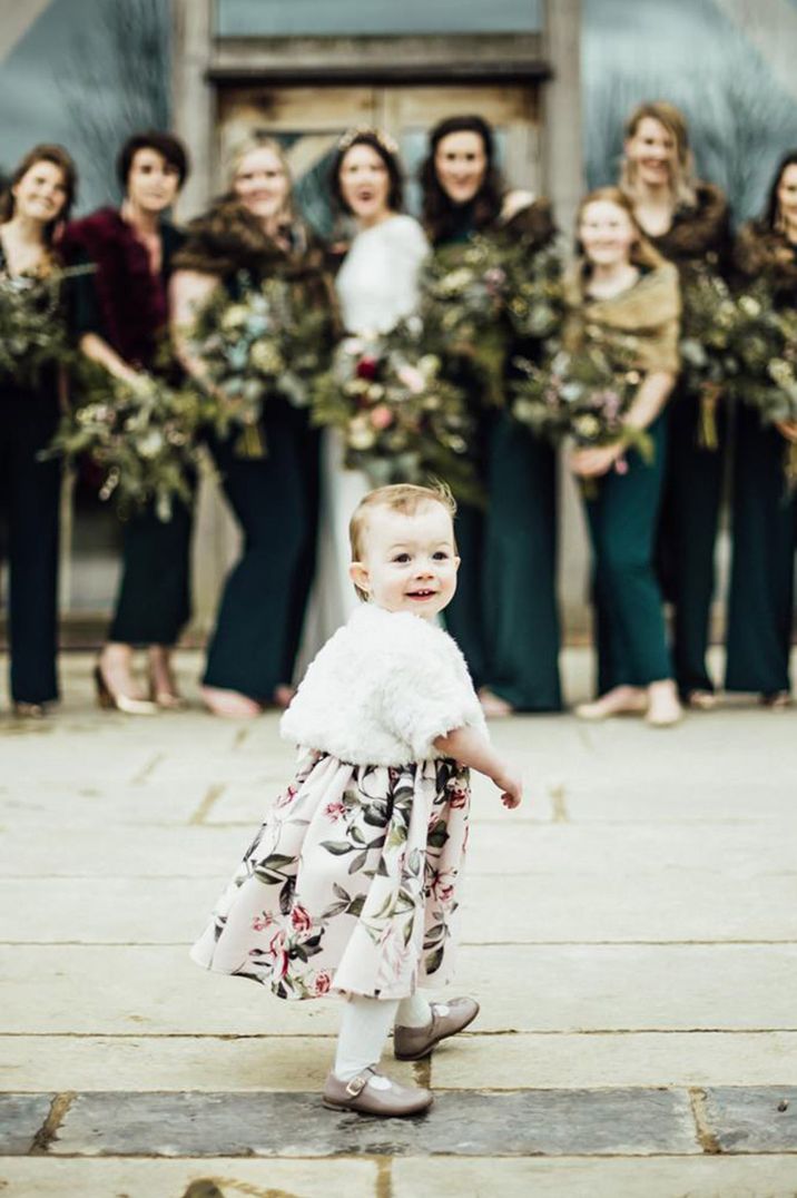 Flower girl in floral dress with fluffy white cover up