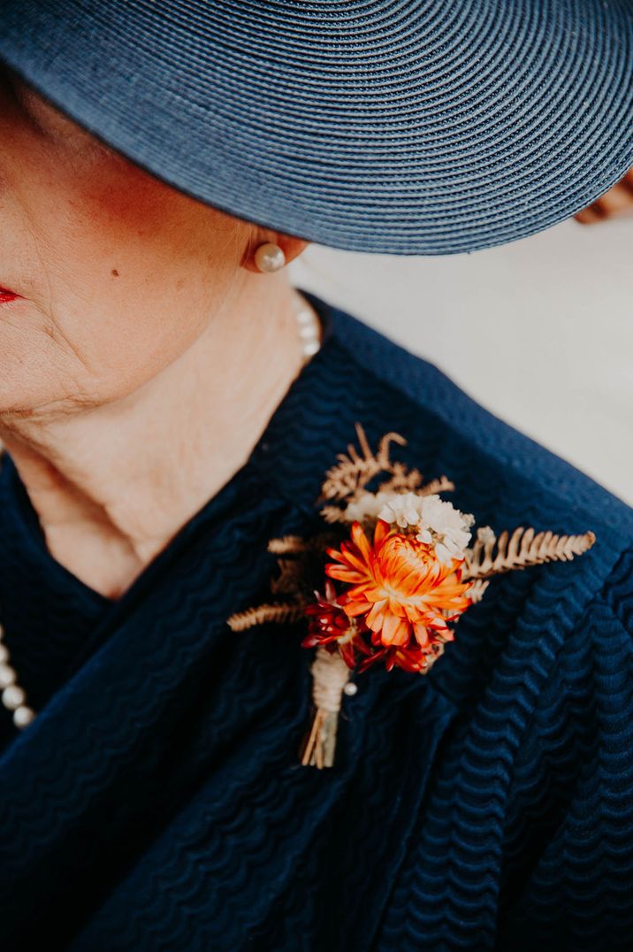 Dried wedding flowers with bright orange seasonal fall wedding buttonhole for mother of the bride 