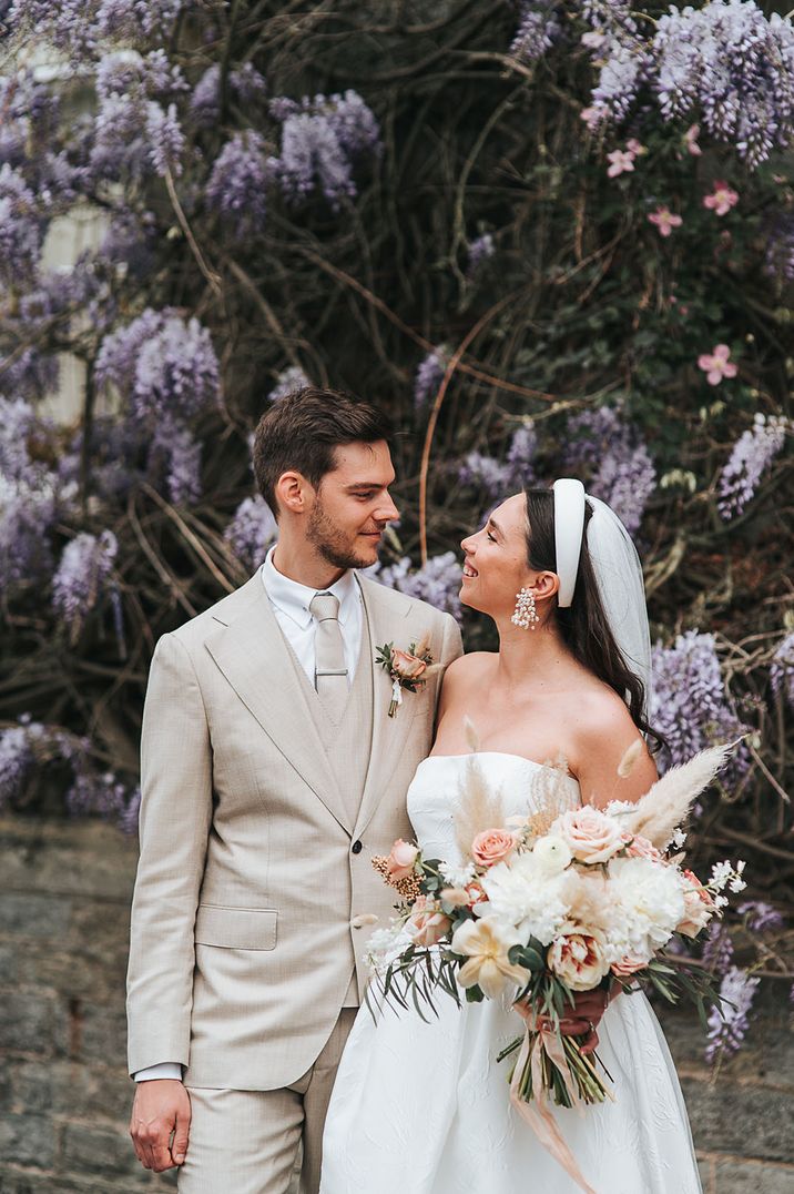 Bride wearing headband holding neutral wedding bouquet for spring wedding with pampas grass 