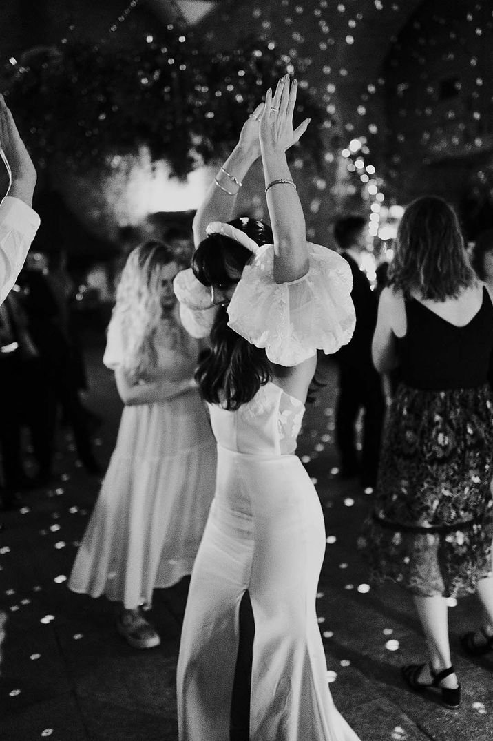 Bride dances during wedding reception party in black & white image