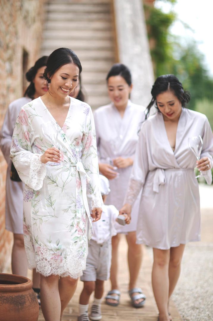 Bride in a floral satin getting ready robe with her bridal party in dusky pink bridesmaid robes